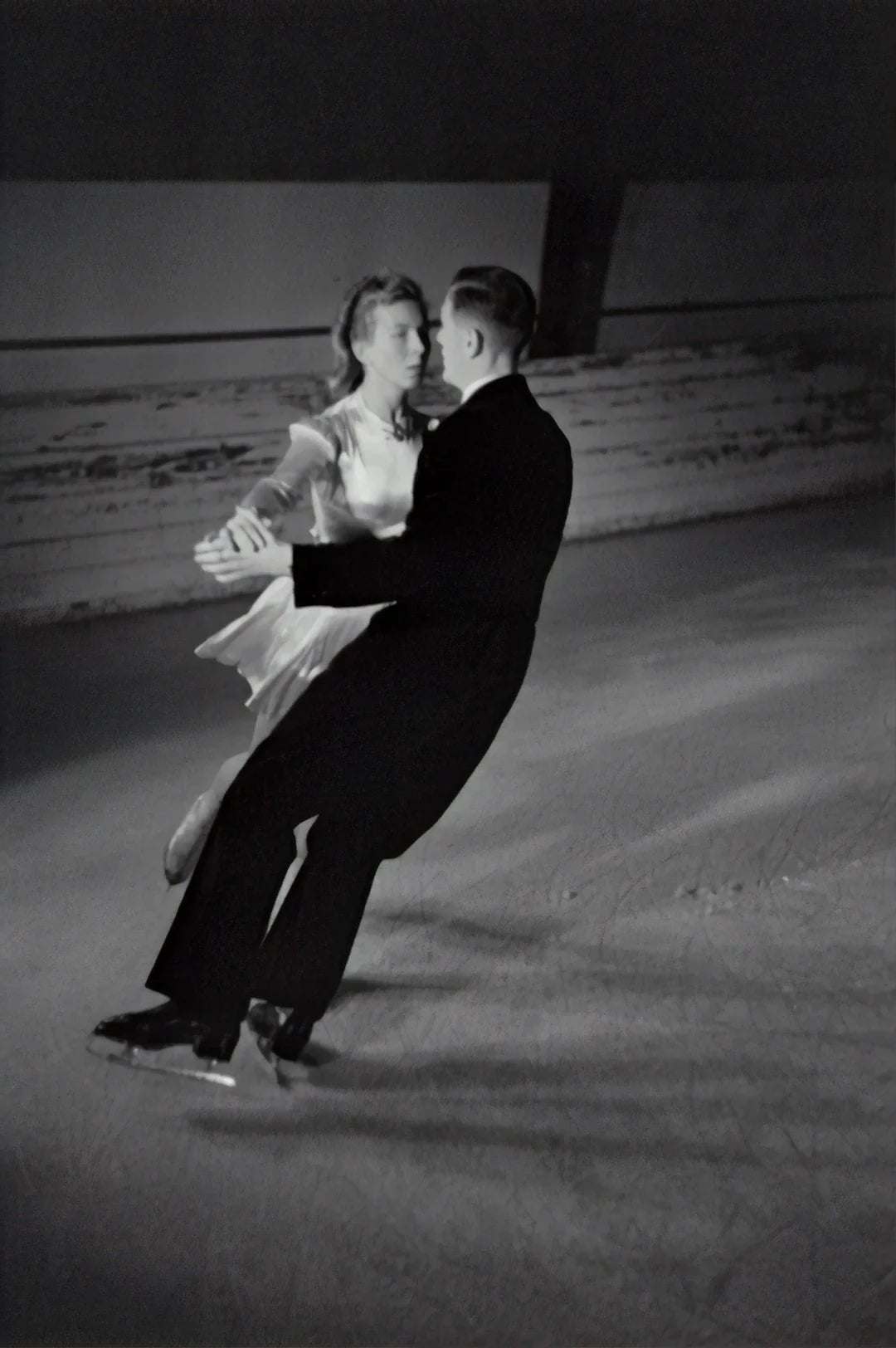 black and white photo of a couple figure skating on ice rink showcasing elegance and balance