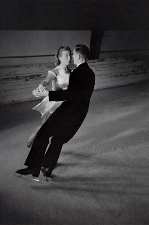 black and white photo of a couple figure skating on ice rink showcasing elegance and balance