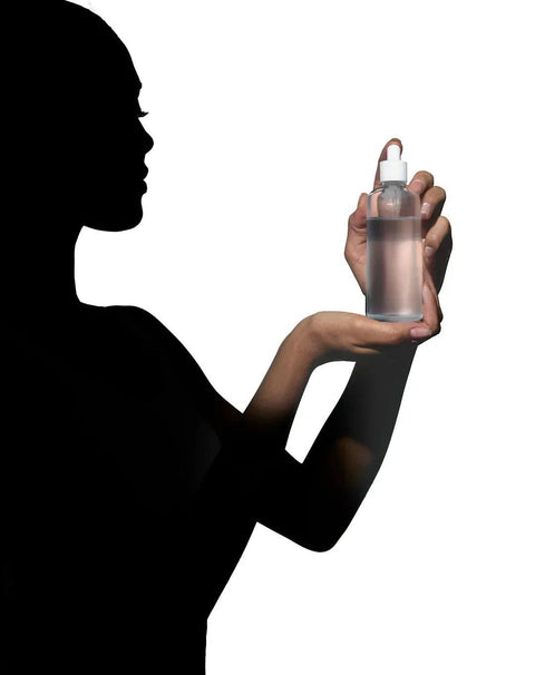 Silhouette of a person holding a clear dropper bottle representing natural supplements.